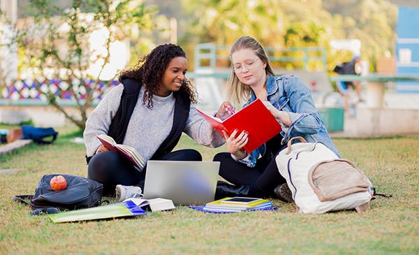 两个女大学生坐在草坪上